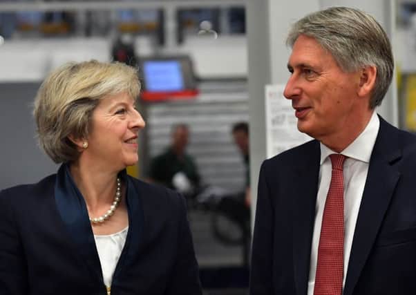 Theresa May and Philip Hammond, the Chancellor, are tasked with delivering Brexit.
