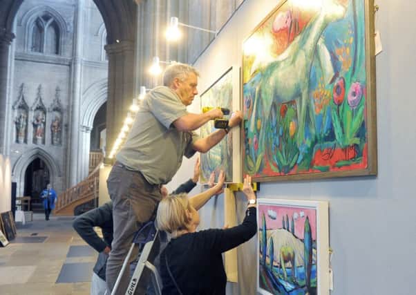Hanging artwork at Ripon Cathedral ready for the Great North Art Show.