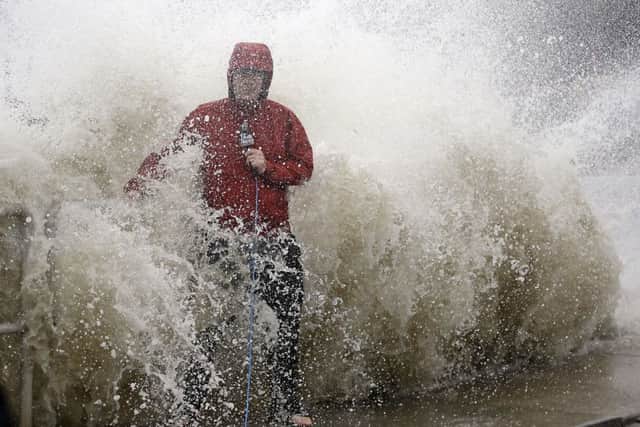 A news reporter doing a stand up near a sea wall in Cedar Key, Florida., is covered by an unexpected wave as Hurricane Hermine nears the Florida coast.