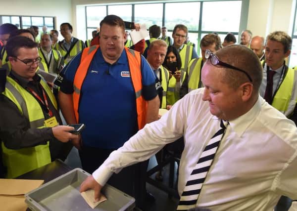 Sports Direct founder Mike Ashley empties his pockets of bank notes  during a mock search at the Sports Direct headquarters in Shirebrook, Derbyshire.