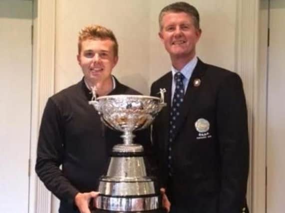 Ben Hutchinson receives the Yorkshire amateur championship trophy from YUGC president Jonathan Plaxton after his victory at Moortown.