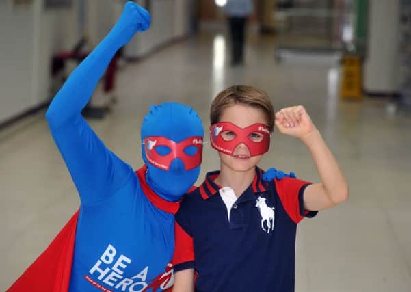The Be A Hero mascot with transplant patient James Hodgson. Picture by Tony Johnson.