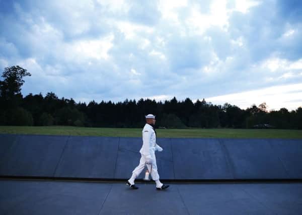 Candles in memory of the passengers and crew of Flight 93, are carried to the Wall of Names at the Flight 93 National Memorial in Shanksville.