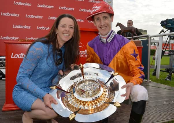 Jockey George Baker and trainer Laura Mongan celebrate after their victory with Harbour Law in the Ladbrokes St Leger Stakes.