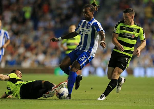 Brighton & Hove Albion's Gaetan Bong (middle) is challenged by Huddersfield Town's Jonathan Hogg (left) and Rajiv van La Parra. Picture: Gareth Fuller/PAclub/league/player publications.
