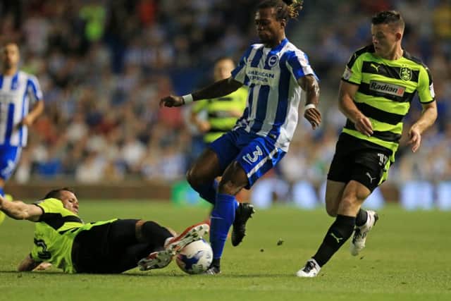 Brighton & Hove Albion's Gaetan Bong is challenged by Huddersfield Town's Jonathan Hogg, left, and Harry Bunn. Picture: Gareth Fuller/PA