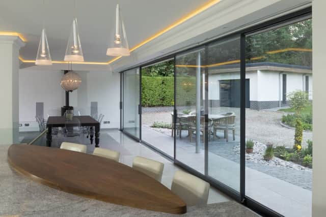 The extension features sliding doors with aluminium frames  by Fineline
