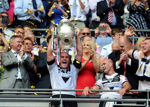 Hull FC captain Gareth Ellis lifts the Cup to the disappointment of Warrington Wolves (Picture: Jonathan Gawthorpe).