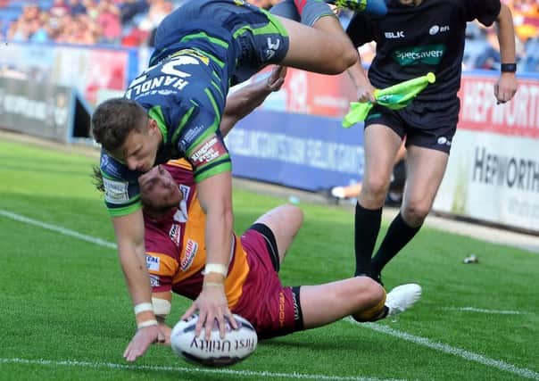Rhinos Ash Handley goes over Giants' Scott Grix to score a try.  Picture Tony Johnson.