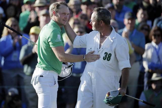 Danny Willett, of England, is congratulated by Lee Westwood's caddy Billy Foster on the 18th hole after finishing the final round of the Masters golf tournamentin April this year. Picture: AP.