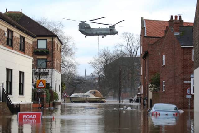A Chinook helicopter delivers materials to repair to the flood defence systems in York, North Yorkshire, December 28 2015. The flood gate which protects the city had to be raised after the pumping station was flooded. See Ross Parry story RPYFLOOD; Flood-stricken residents across the North of England have an anxious wait as flood levels are expected to keep rising throughout the night. Brave locals watched on outside their homes as soldiers waded into the water to rescue residents in York, North Yorks. The Foss flood barrier - which protects the city from flooding - was reportedly left open because engineers feared that the defence would fail if it was left in the down position. York was in deadlock today with over 30 road closures as 200 soldiers were deployed in various parts of the city. Pic: Ross Parry