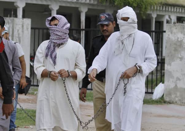 A Pakistani police officer, second right, escorts father Muhammad Shahid, right, and ex-husband Muhammad Shakeel into court