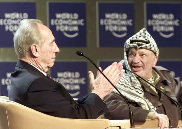 In 2001, Shimon Peres applauds Palestinian leader Yasser Arafat, right, before Arafat speaks at the Davos World Economic Forum.