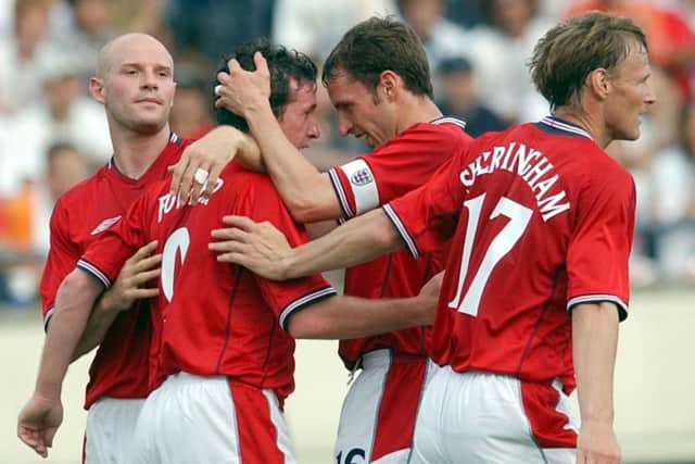 Danny Mills, left, and Gareth Southgate, second right, celebrate a Robbie Fowler while playing for England ahead of the 2002 World Cup against Cameroon in Japan. Picture: AP/Adam Butler.