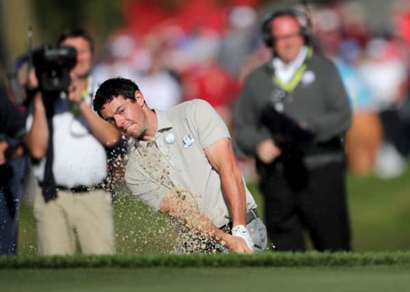 Europe's Rory McIlroy plays a shot from the bunker on the 14th.