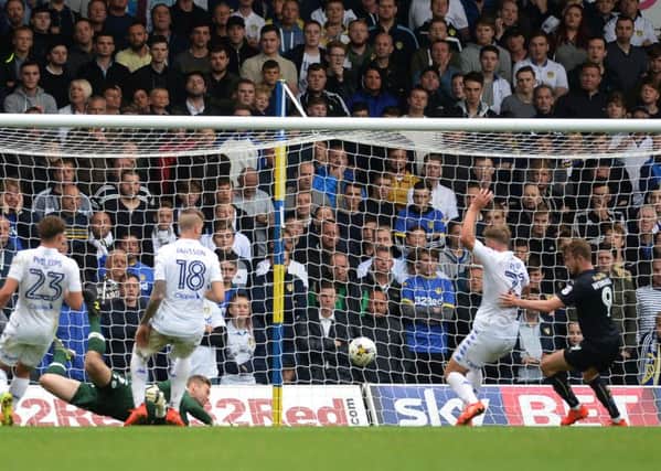 Leeds United's Charlie Taylor scores an own goal under pressure from Barnsley's Sam Winnall (Picture: James Hardisty).