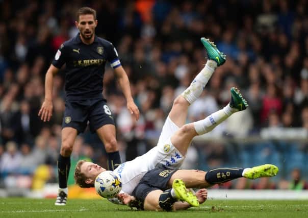 Leeds United's Eunan O'Kane, is tackled hard to the ground by Barnsley's Angus MacDonald. Picture James Hardisty