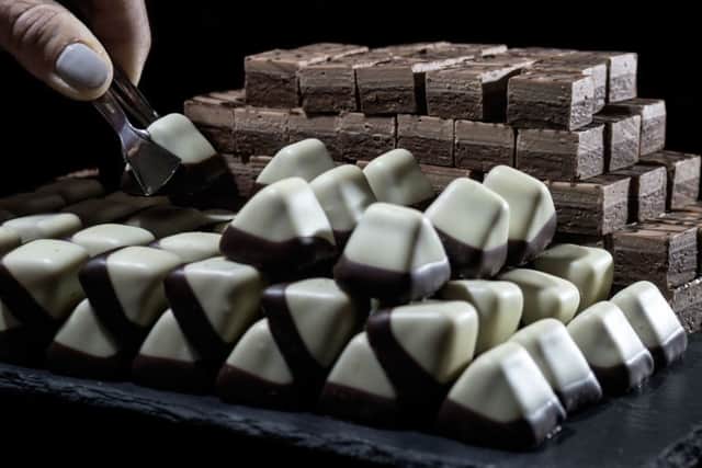 A slate of luxury chocolates Lavenstein, Castle Peak, Marzipan with Mocha Cream, and Praline Cube, Light and Dark.