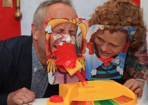 Alan Twigg (left) plays Pie Face Showdown with his son Archie, 11. PIC: PA