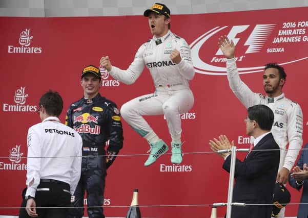 Nico Rosberg celebrates at Suzuka flanked by second-placed Red Bull's Max Verstappen, left and Mercedes team-mate Lewis Hamilton, right, of Britain, who finished third.