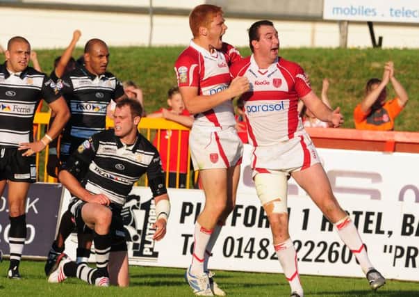 Hull KR's Paul Cooke (right) celebrates his second try with Kris Welham as Hull FC players show their dismay during a dergby clash in July 2009. Picture: Anna Gowthorpe/PA