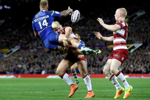 Warrington Wolves' Joe Westerman is tackled by Wigan Warriors George Williams at Old Trafford. Picture: Martin Rickett/PA.