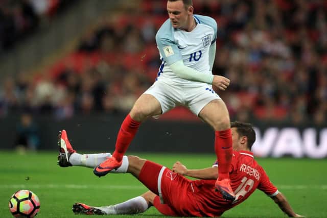 England's Wayne Rooney jumps over a challenge from Malta's Bjorn Kristensen. (Picture: PA)
