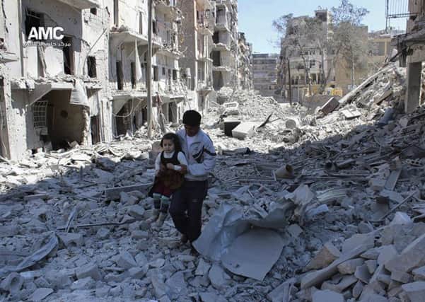 A young child is rescued from the ruins of Aleppo.