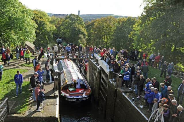 Historic boat and floating museum the Kennet and a flotilla of other boats pass through the 3 rise and 5 Rise Locks in Bingley
