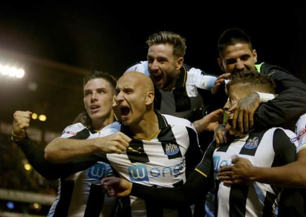 Newcastle United's Dwight Gayle is mobbed after he scores his opening goal.