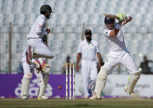 England's Jonny Bairstow, right, plays a shot, as Bangladesh's Mominul Haque, left, jumps during the third day of their first cricket test match in Chittagong, Bangladesh, Saturday, Oct. 22, 2016. (AP Photo/A.M. Ahad)