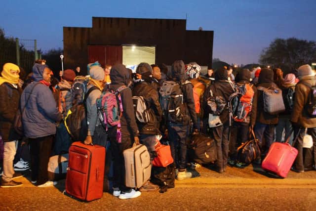 Migrants line-up to register at a processing centre in "the jungle" near Calais