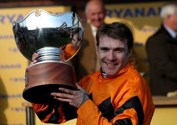 Jockey Tom Scudamore celebrates with the trophy after winning the Ryanair World Hurdle on Thistlecrack at the 2016 Cheltenham Festival (Picture: David Davies/PA Wire).