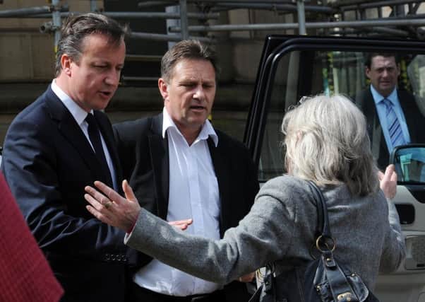 Prime Minister David Cameron is confronted by Kathleen Simpson as he leaves the town hall in Todmorden, West Yorkshire, after a meeting with council officials and emergency services workers in June 2012.