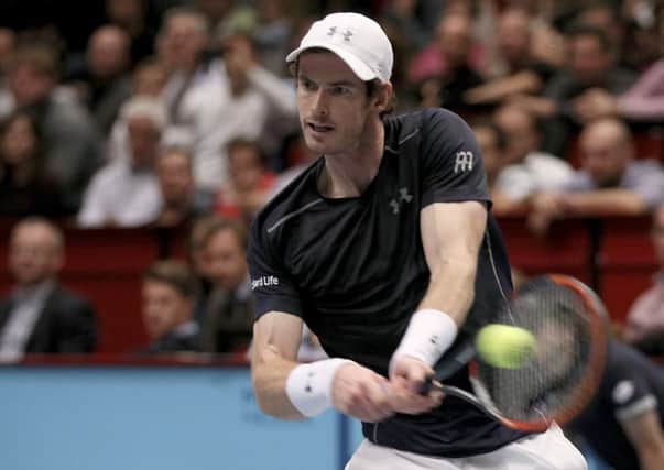 Andy Murray of Great Britain returns a ball to John Isner.