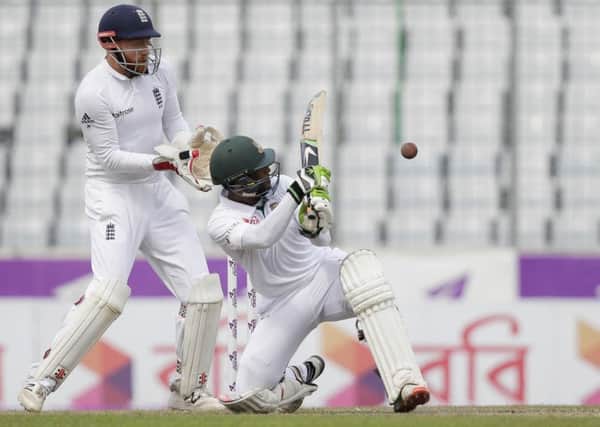 Bangladesh's Shuvagata Hom plays a shot as England's wicketkeeper Jonny Bairstow watches during the third day's play. Picture: AP/AM Ahad.