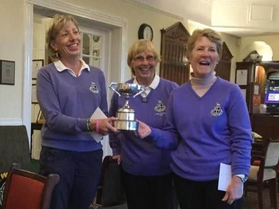 EYLWGA match play champions Dianne Kingswood and Joan Cormack receive the trophy from the association's president Pam Imison, a Hessle club-mate.
