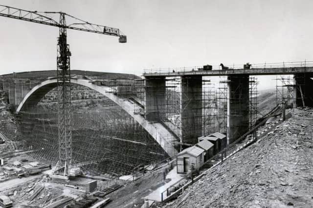 JULY 1969: The graceful arch of the new bridge emerges above its web of scaffolding to span the gap torn in the Scammonden Valley for the M62 motorway.