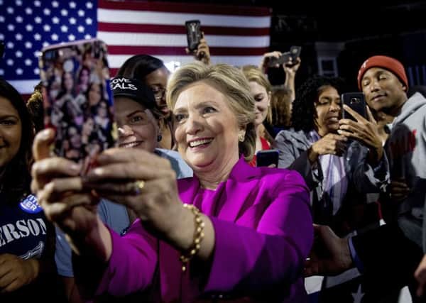 Democratic presidential candidate Hillary Clinton, left, and performer Pharrell Williams, right, greets members of the audience after speaking at a rally at Coastal Credit Union Music Park at Walnut Creek in Raleigh, N.C.