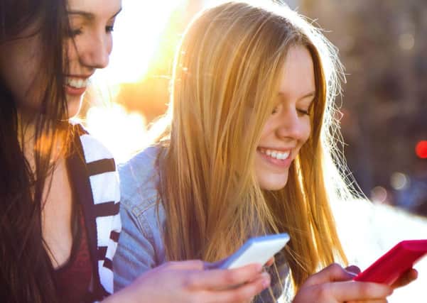 A Generic Photo of teen girls looking at their mobile phones and giggling. See PA Feature. Picture credit should read: PA Photo/thinkstockphotos. WARNING: This picture must only be used to accompany PA Feature.