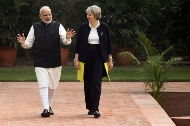 Theresa May and  Indian Prime Minister Narendra Modi walk through the gardens of Hyderabad House in New Delhi
