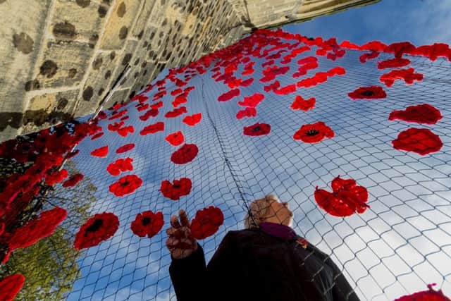 Kath Forsdyke, of Easingwold, admiring the "river" of poppies on  St Mary's Church, Thirsk.