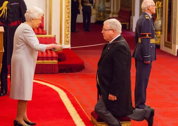 Sir Patrick McLoughlin receives his knighthood from the Queen.