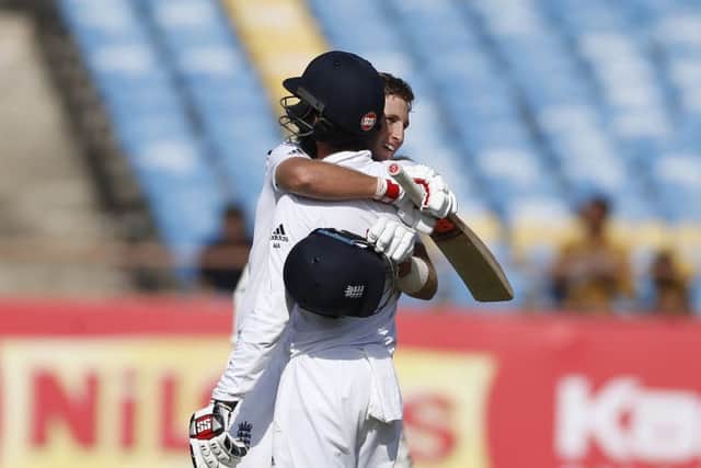 Root is greeted by Moeen Ali after he scored his century (AP Photo/Rafiq Maqbool)