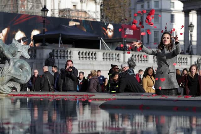 Laura Wright throws poppies in the fountain during an event in London's Trafalgar Square to mark Armistice Day.