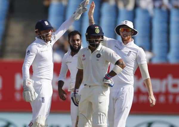 England's players, including Adil Rashid, third left, celebrate the wicket of Indian cricket captain Virat Kholi on the fourth day of in Rajkot. Picture: AP Photo/Rafiq Maqbool.