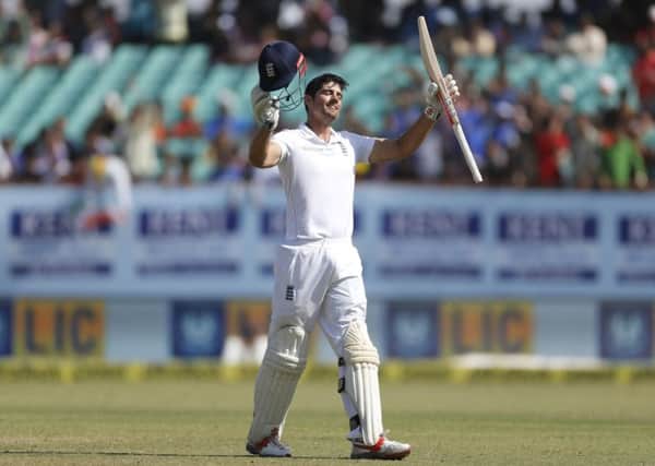 LEADING FROM THE FRONT: England's cricket captain Alastair Cook raises his bat and helmet after scoring a century on the fifth day against India in Rajkot. Picture: AP/Rafiq Maqbool