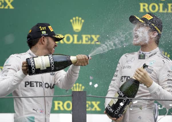 Mercedes driver Lewis Hamilton, of Britain, sprays champagne over the face of teammate Nico Rosberg, of Germany, at the podium of the Brazilian Formula One Grand Prix at the Interlagos race track in Sao Paulo, Brazil (AP Photo/Andre Penner)