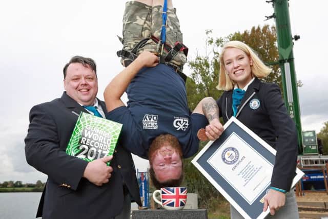 Craig Glenday and Sofia Greenacre of Guinness World Records confirm the record  for the highest dunk of a biscuit by a bungee jumper, which is 73.41 m (240 ft 10 in)