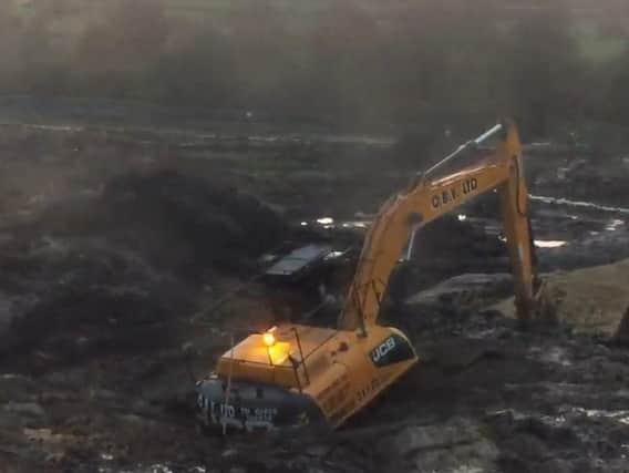 The sinking JCB. Photo & video: Streets Of Cookridge Facebook page